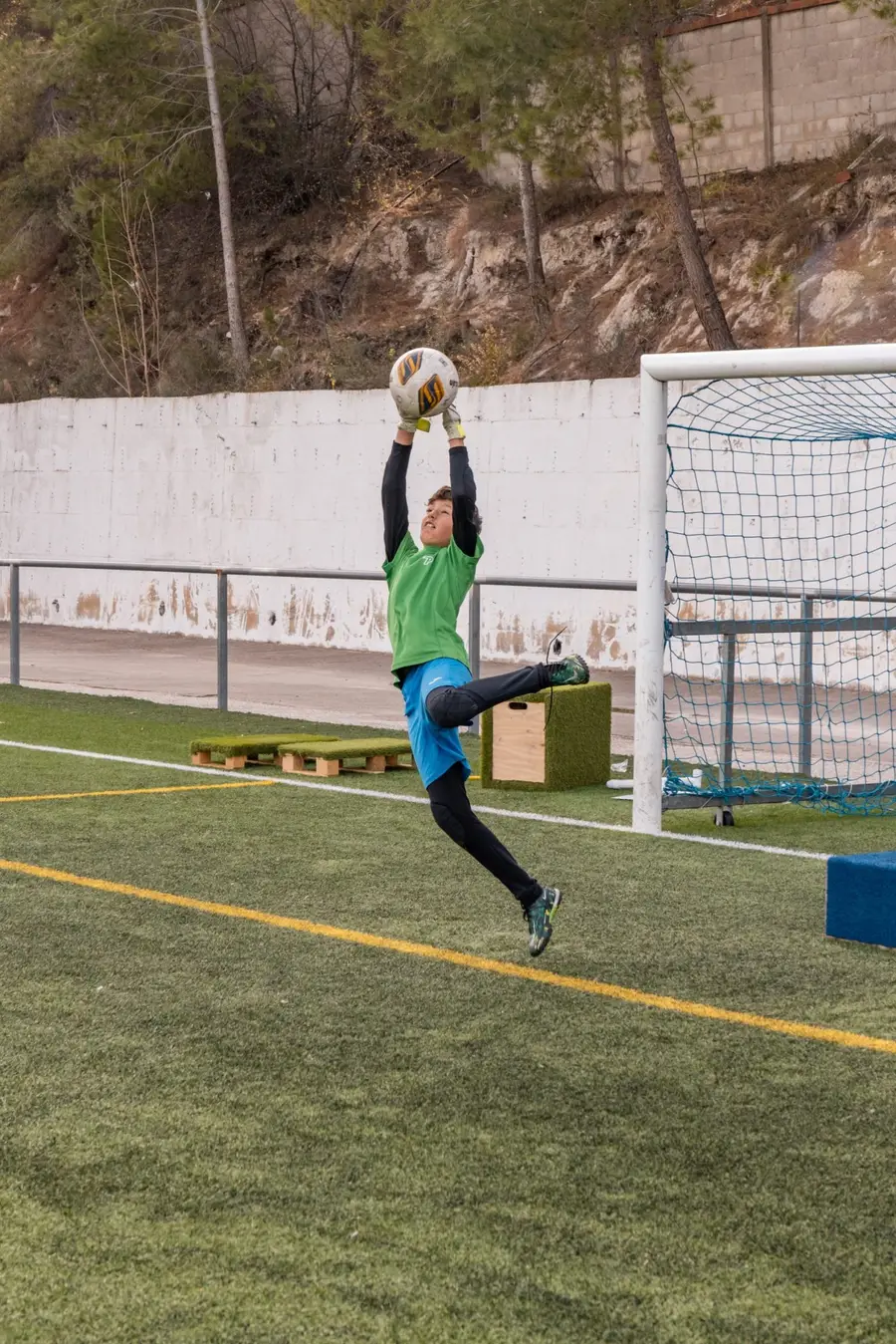 Portero saltando para atrapar un balón alto