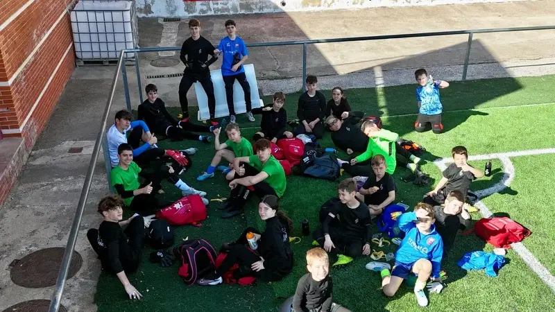 Alumnos sentados en el césped durante un descanso del campus